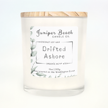 Drifted Ashore 11 oz candle in a white glass jar with a natural pine lid