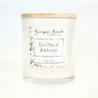 Drifted Ashore 8 oz candle in a white glass jar with a natural pine lid