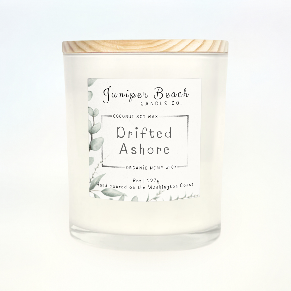 Drifted Ashore 8 oz candle in a white glass jar with a natural pine lid