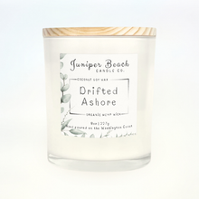 Drifted Ashore 8 oz candle in a white glass jar with a natural pine lid